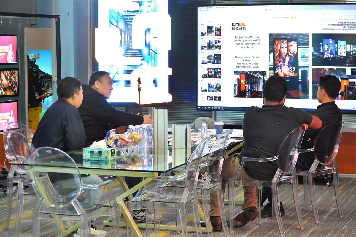  CNLC team and clients discussing custom LED display solutions for outdoor advertising.