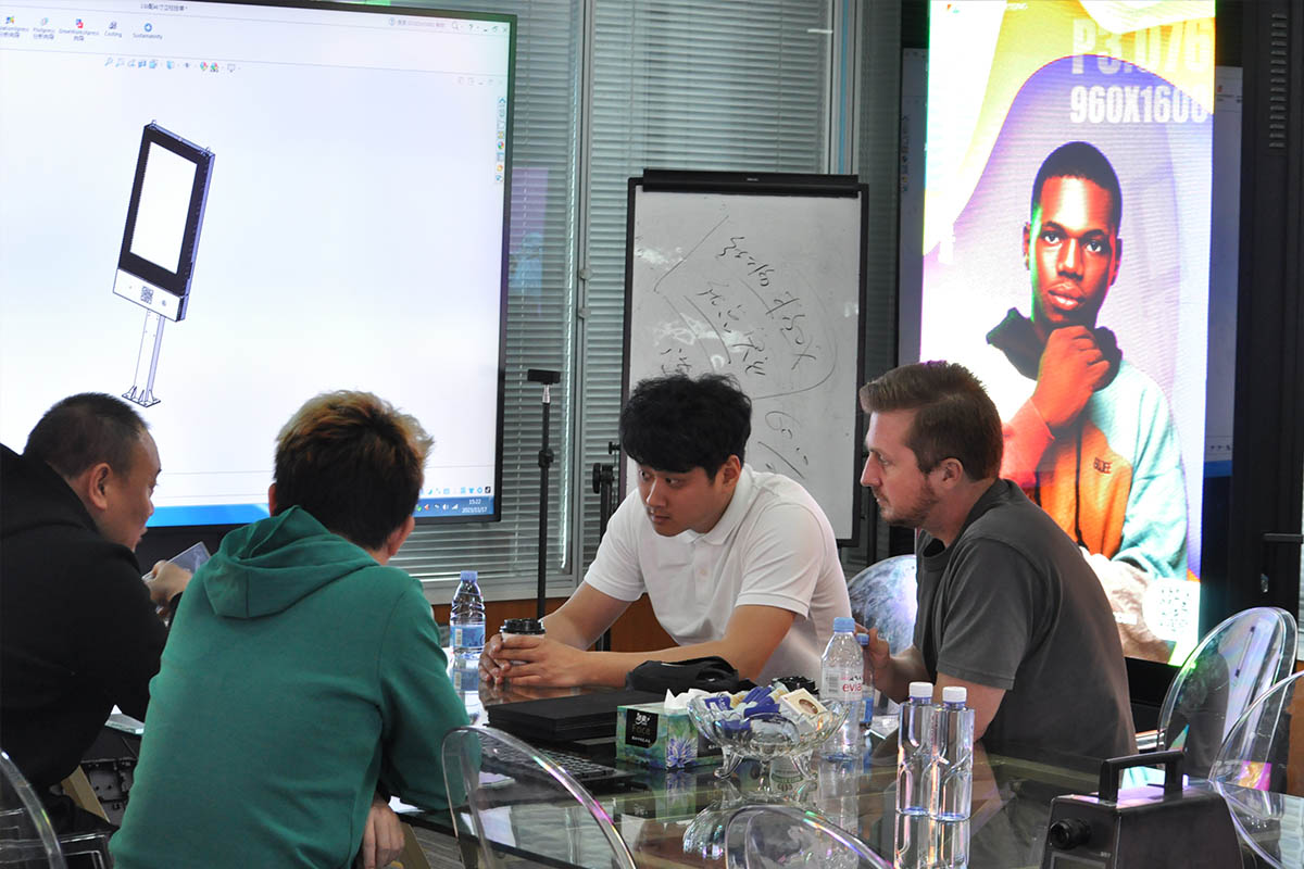 Business partners analyzing interactive touch solutions for retail digital signage.