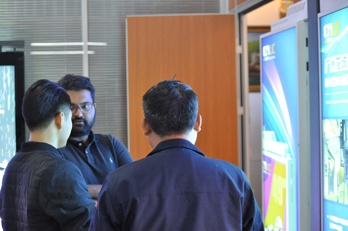 Business partners analyzing interactive touch solutions for retail digital signage.